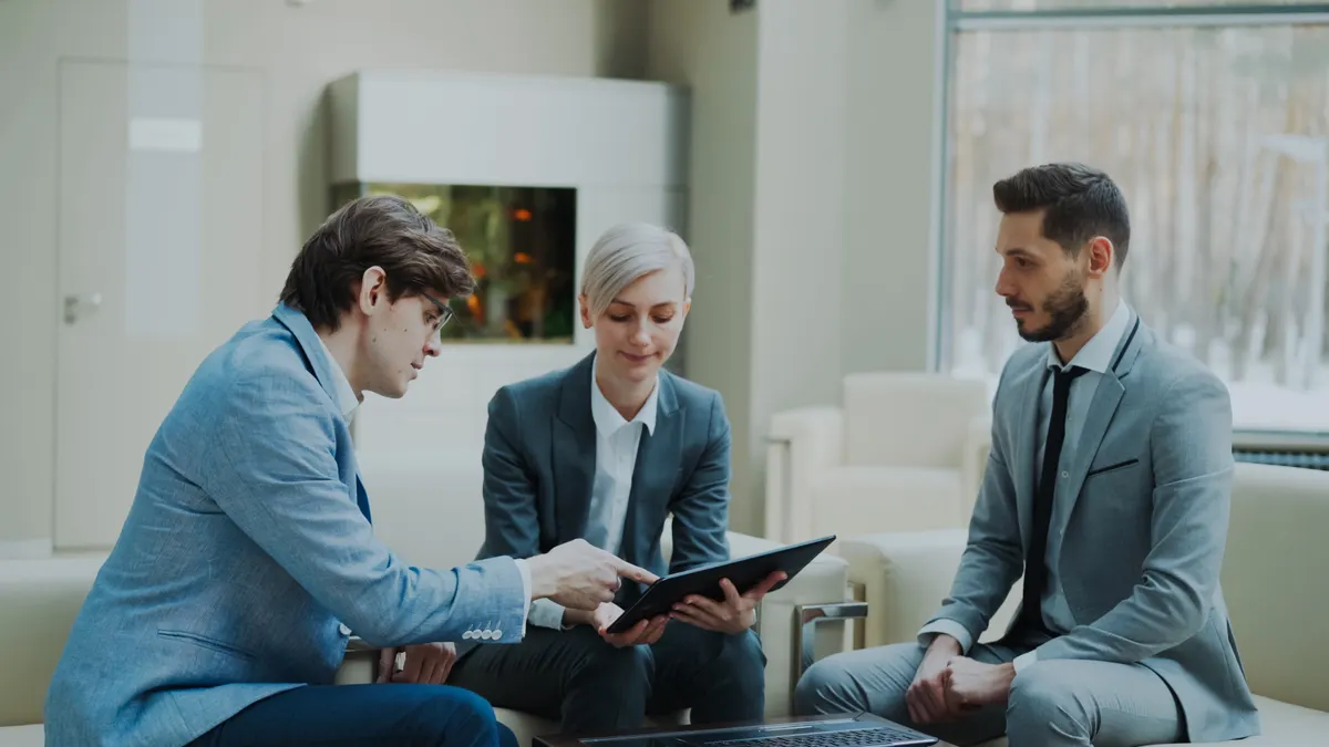 Consultants discussing technology strategy documents in a meeting