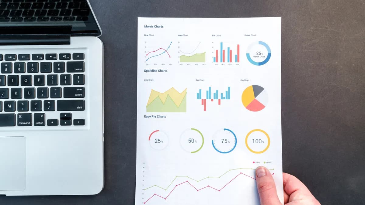 Search performance charts and analytics printouts beside a laptop